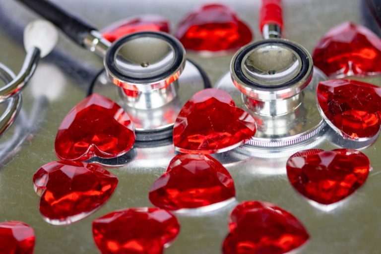 a stethoscope and some red hearts on a table